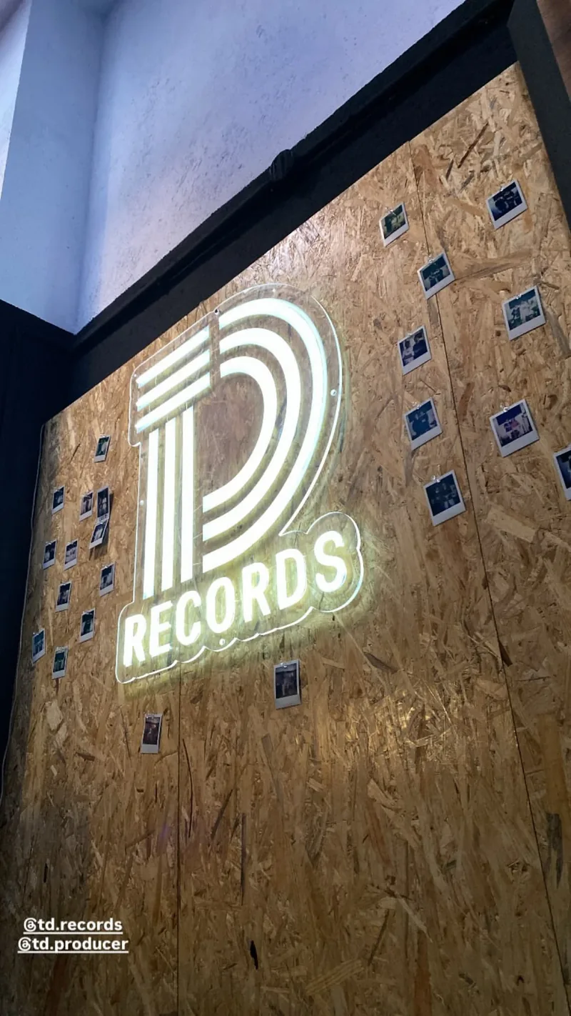 El rótulo de TD Records en el estudio, con la pared de polaroids detrás